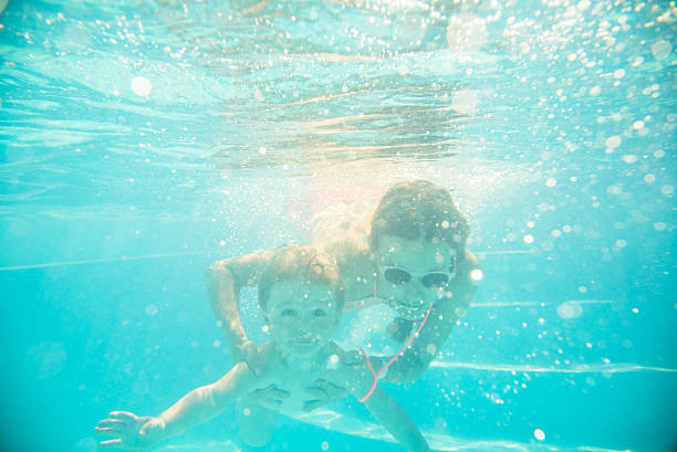 istock Young mother swims underwater with your child 495268682