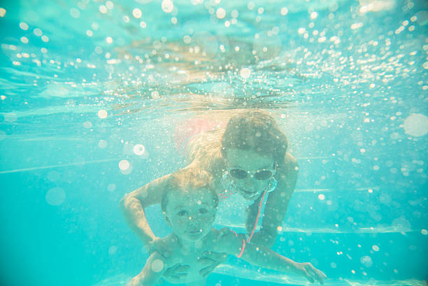 istock Young mother swims underwater with your child 495268736