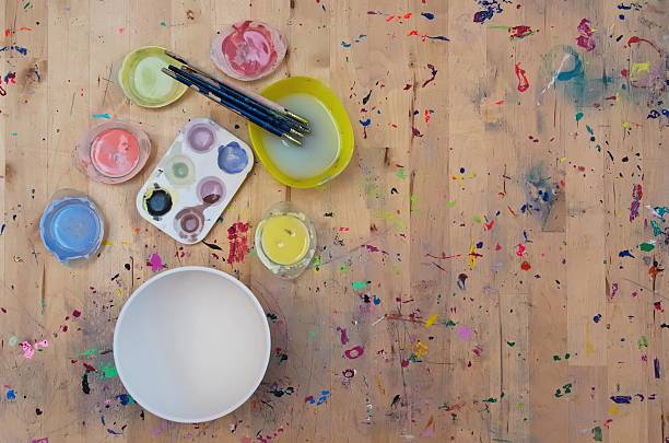 istock Watercolor paint, paintbrushes and a white bowl on light colored 495268934