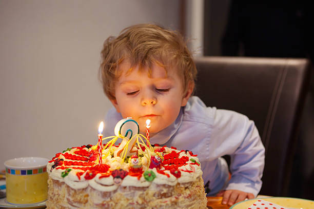 istock Kid celebrating birthday and blowing cake candles 495270610