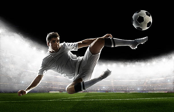 istock Soccer player kicking ball in stadium 495271264