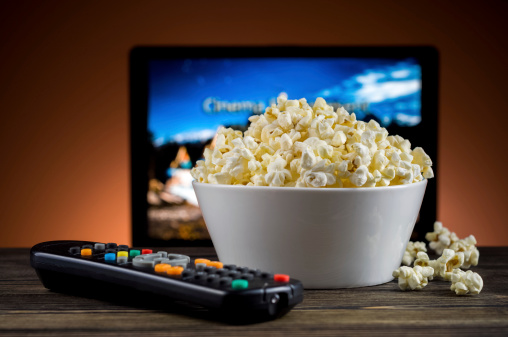 Popcorn and a remote control for the TV background