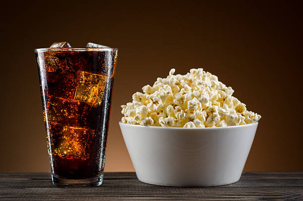 попкорн и кокс на столе - popcorn snack bowl corn стоковые фото и изображения