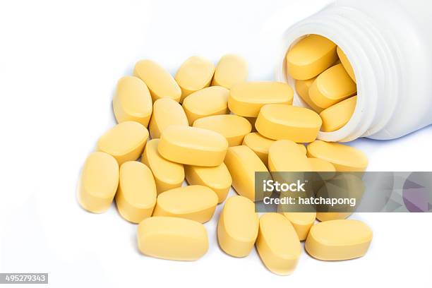 Yellow Pills Spilling Out Of A Medicine Bottle Stock Photo - Download Image Now - Accessibility, Acetylsalicylic Acid, Addiction