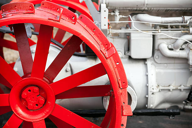 istock Fragment of old white tractor with red wheel 495279445
