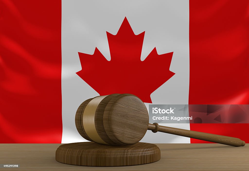 Canada law and justice system with national flag A wooden gavel used in court rulings resting in front of the flag of Canada. 2015 Stock Photo