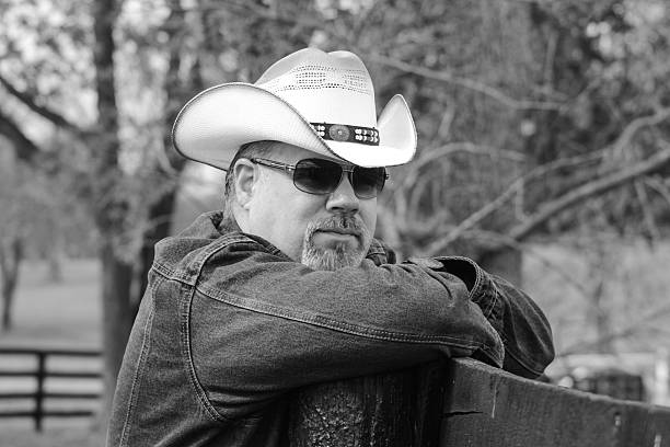 istock Cowboy Leaning on Fence Poses For Camera 495292538