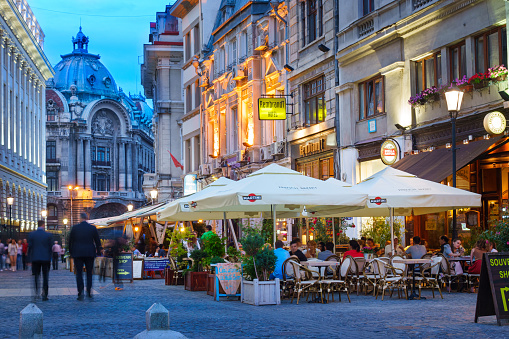 Bucharest, Romania - May 27, 2014: People sit at cafes and walk in the old town of Bucharest, Romania.