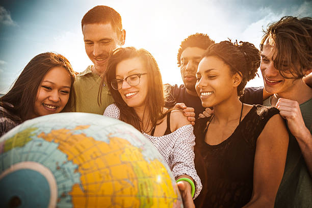 gruppo di amici tenendo un globo di terra - teenager globe women world map foto e immagini stock