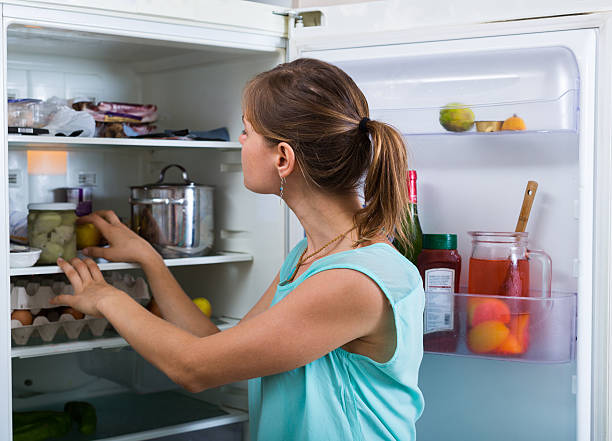 Woman near full fridge