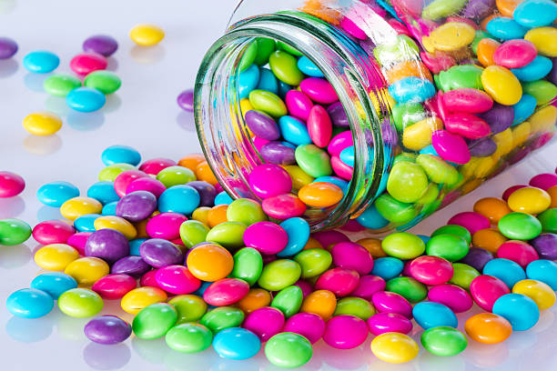 istock Colorful candies with glass jar on white background 495311502