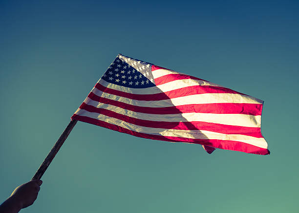 istock American flag over blue sky 495329318