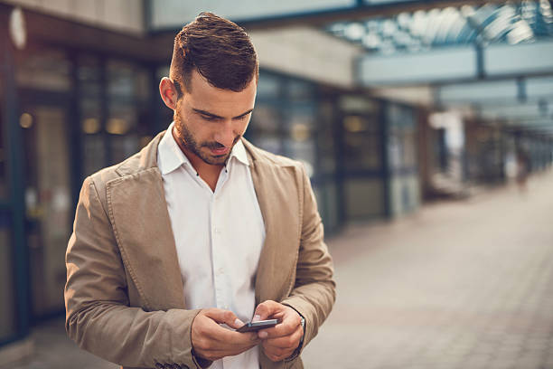 istock Smiling businessman reading a text message on mobile phone. 495335164