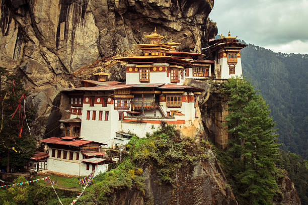 tigres nest taktshang goemba (mosteiro), butão, em uma montanha cliff - tibetan script - fotografias e filmes do acervo