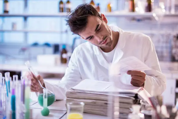 Photo of Young scientist reading scientific data in a laboratory.