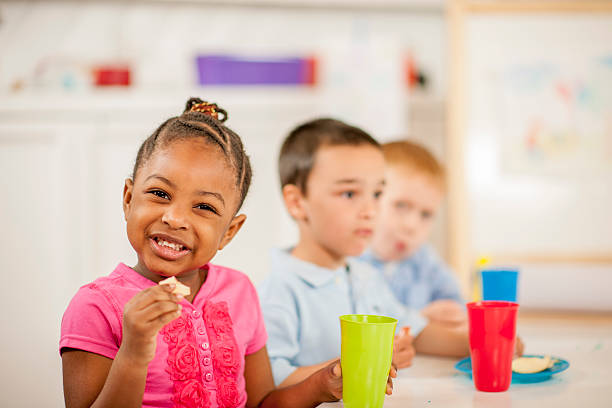 dziewczynka jedzenie obiad w szkole - apple eating healthy eating friendship zdjęcia i obrazy z banku zdjęć