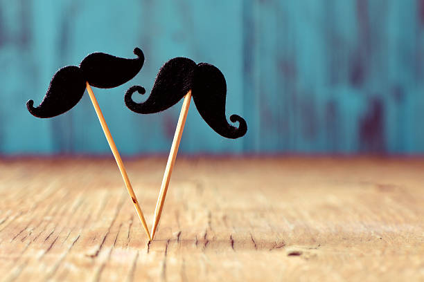 istock felt mustaches in sticks on a wooden surface 495348276