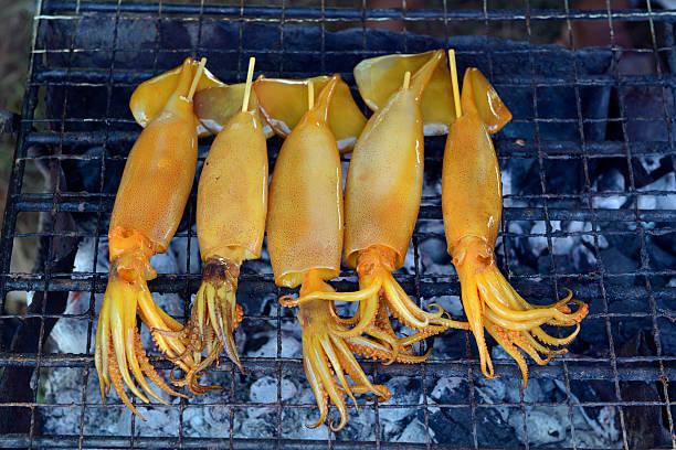 Squid on a grill at a folk festival in the province of Amnat Charoen northwest of Ubon Ratchathani in northeastern Thailand in South East Asia.
