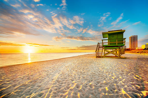 Miami South Beach sunrise Miami South Beach sunrise with lifeguard tower and coastline with colorful cloud and blue sky. south beach stock pictures, royalty-free photos & images