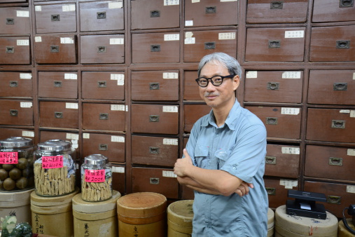 Man folding hands inside Chinese Herbal Shop