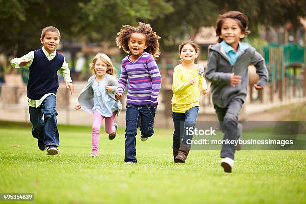 Group Of Young Children Running Towards Camera In Park Stock Photo - Download Image Now