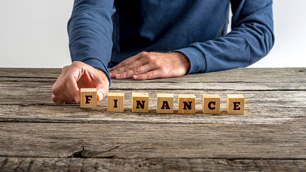 istock Man in blue shirt assembling the word Finance 495354936