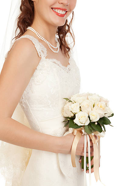 istock Beautyful bride holding her bouquet from roses and smiling. 495356295