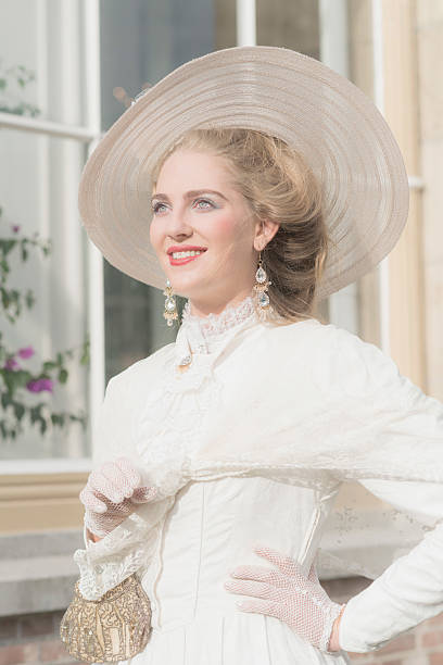 istock Smiling chic victorian woman with hat in front of window. 495356672