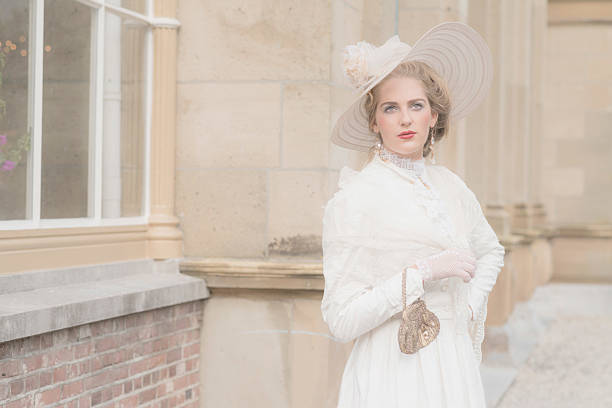 istock Chic victorian woman with hat in front of mansion. 495356764