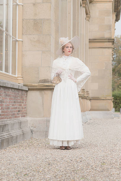 istock Chic victorian woman with hat walking along mansion. 495356808