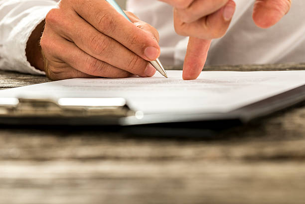 Closeup of male hand pointing where to sign a contract stock photo