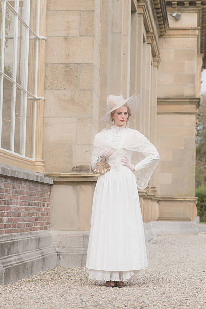 istock Chic victorian woman with hat walking along mansion. 495356842