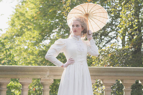 istock Backlit posh victorian woman with parasol standing on bridge. 495357662
