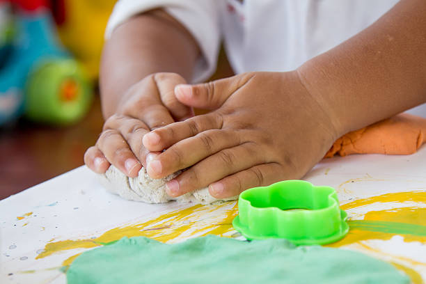 Child hand playing with clay, play doh Child hand playing with clay, play doh putty stock pictures, royalty-free photos & images