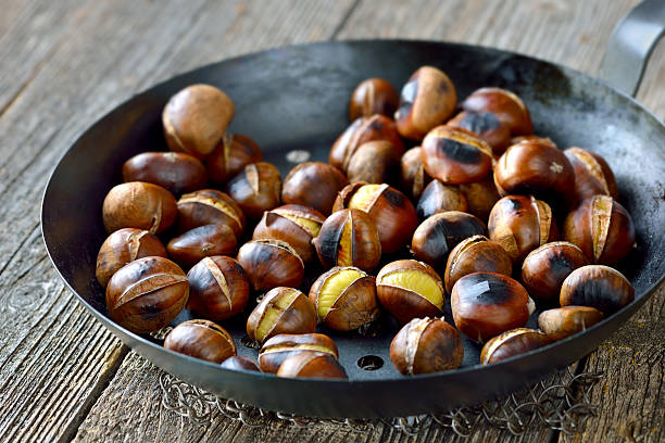 asado castañas - chestnut roasted heat roasted chestnut fotografías e imágenes de stock