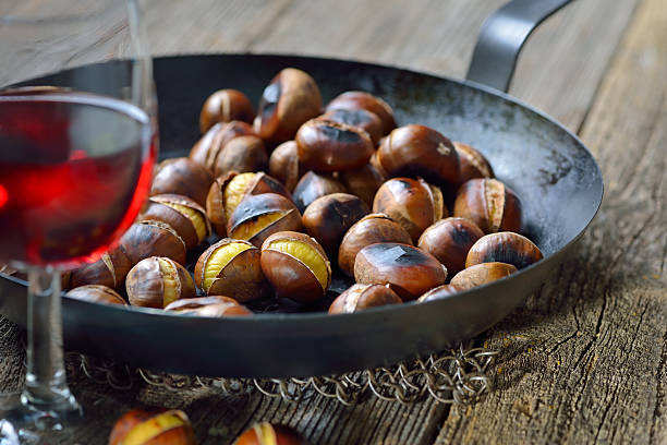 vino y algarrobas - chestnut roasted heat roasted chestnut fotografías e imágenes de stock