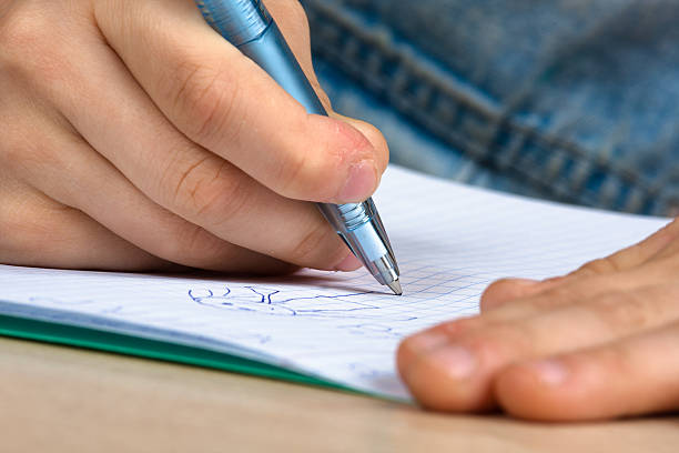 istock hands of child drawing in notebook 495374594