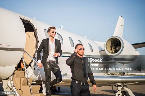 Famous Person With Bodyguard Leaving The Jet Airplane Stock Photo - Download Image Now