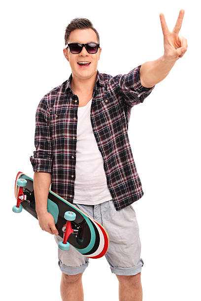 istock Skater holding skateboard and making a peace sign 495378466