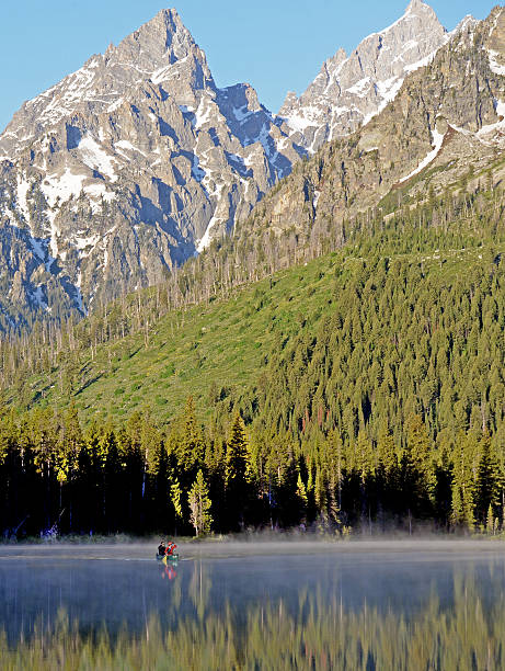 istock canoe glides across String Lake in early morning light. 495380521