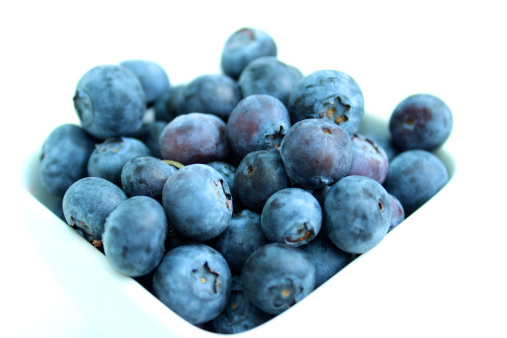 Photo showing a dish of organic fresh blueberries, showing fresh fruit as part of a healthy breakfast.