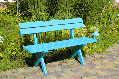 green wooden park bench at the summer garden