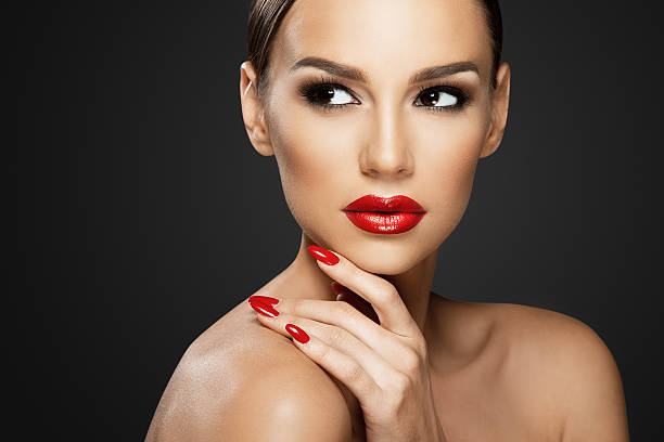 Beautiful woman portrait, beauty on dark background, red nails stock photo