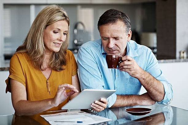 And it's as easy as 'enter'! Shot of a mature couple paying their bills online from home mature couple stock pictures, royalty-free photos & images