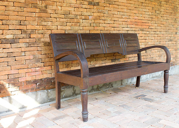 istock wooden bench against brick wall 495415019