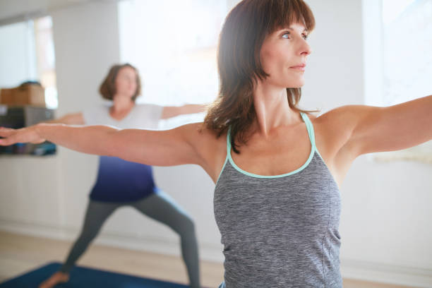 istock Fitness trainer doing the warrior pose at yoga class 495417200