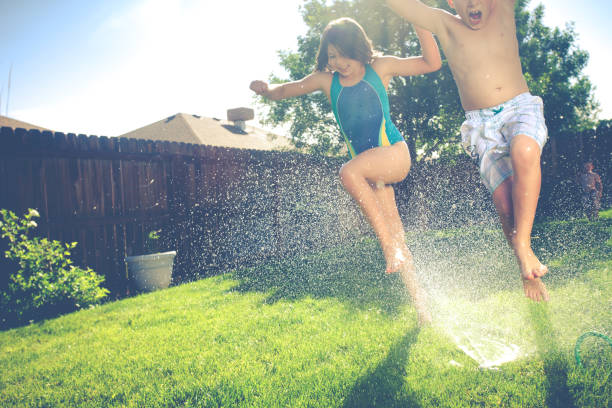 istock Two Kids Running Through Sprinklers 495417635