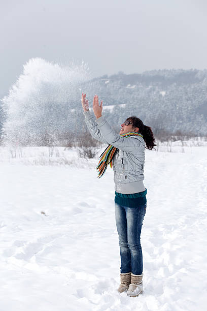 istock Female woman throws snow 495417933