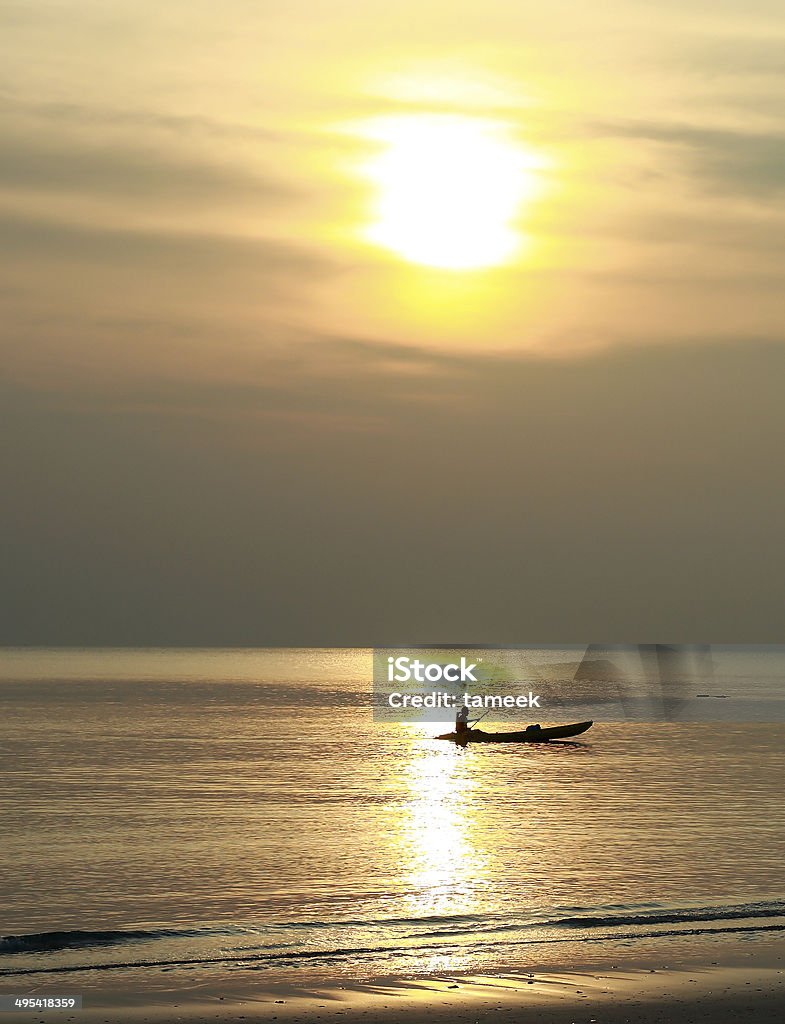 Sunset Sunset above sea with people in kayak Canoeing Stock Photo