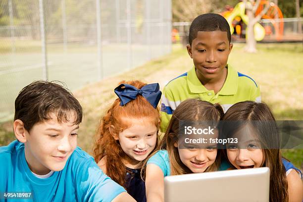 Technology Diverse Group School Children Enjoy Digital Tablet Outdoors Park Stock Photo - Download Image Now